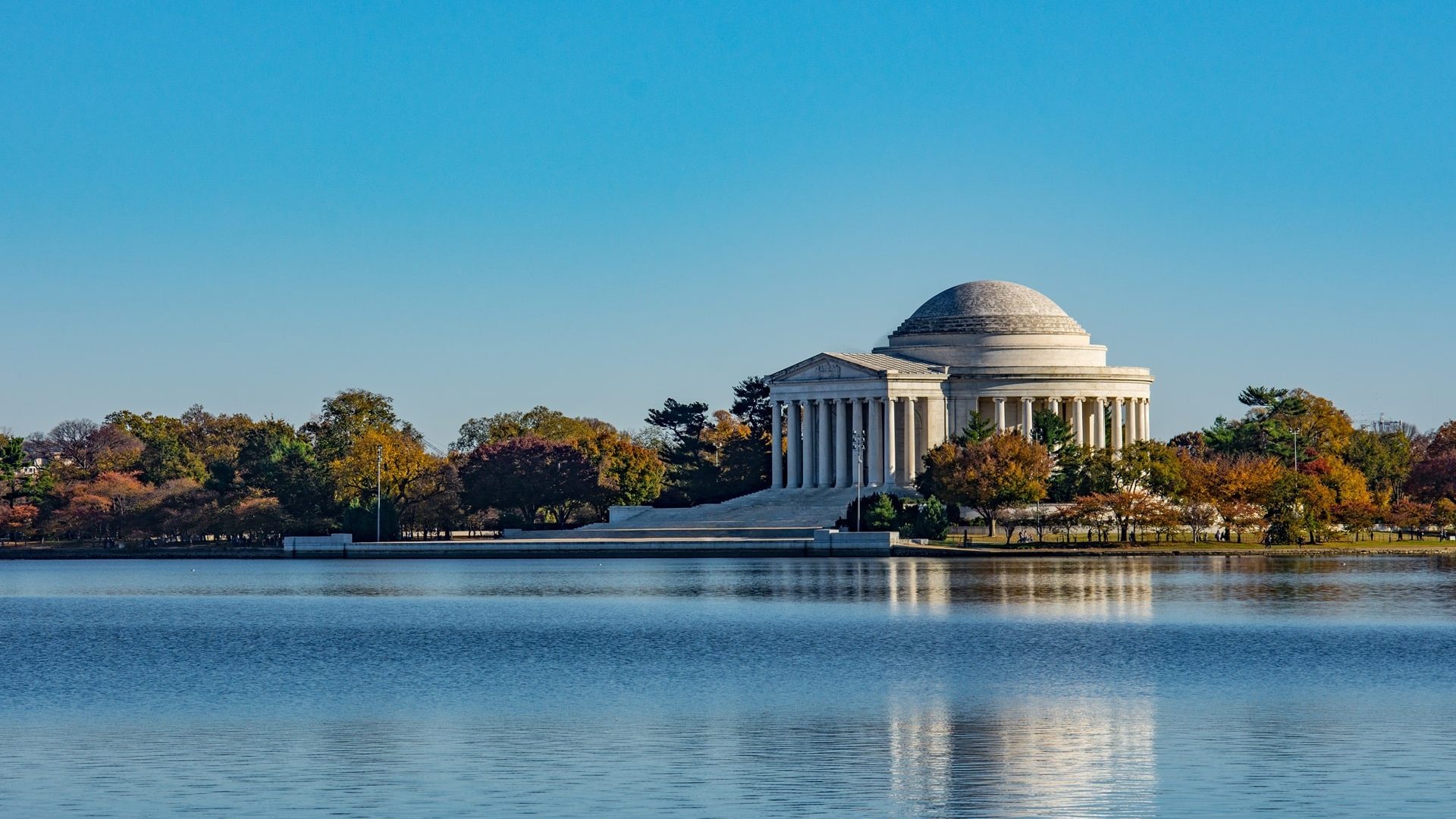 thomas-jefferson-memorial-surrounded-by-lake-trees-sunlight-washington-dc-min